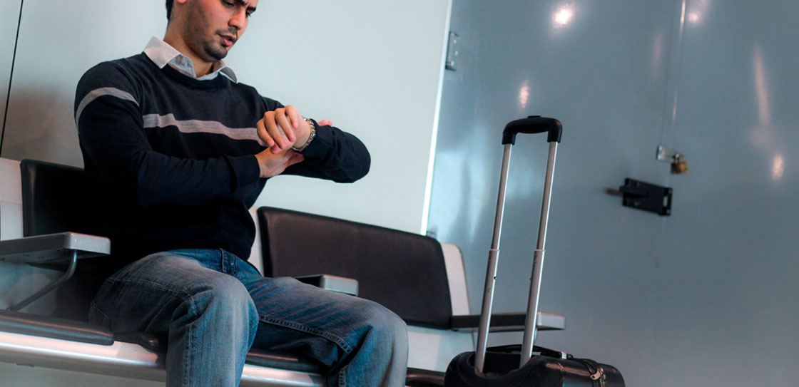 homem preocupado no aeroporto buscando informações sobre indenização por voo cancelado
